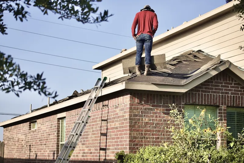 Professional roofer working on a residential roof in Clemmons West